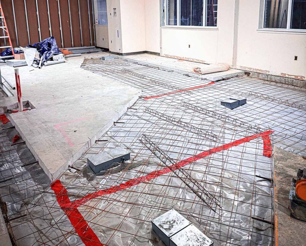 Interior concrete slab demolition and rebar preparation for PET scanner installation inside medical facility